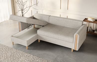 szary narożnik typu L zfunkcja spania i pojemnikiem na pościel, posiada drewniane nóżki