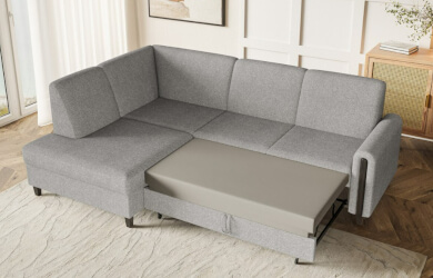 szary narożnik typu L posiadający funkcję spania i pojemnik na pościel