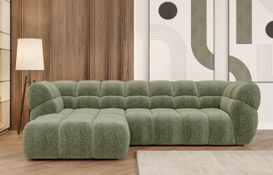 zielony narożnik phantom, posiada liczne przeszycia dekoracyjne siedziska i oparcia, mebel z wysuwanym elektrycznie siedziskiem